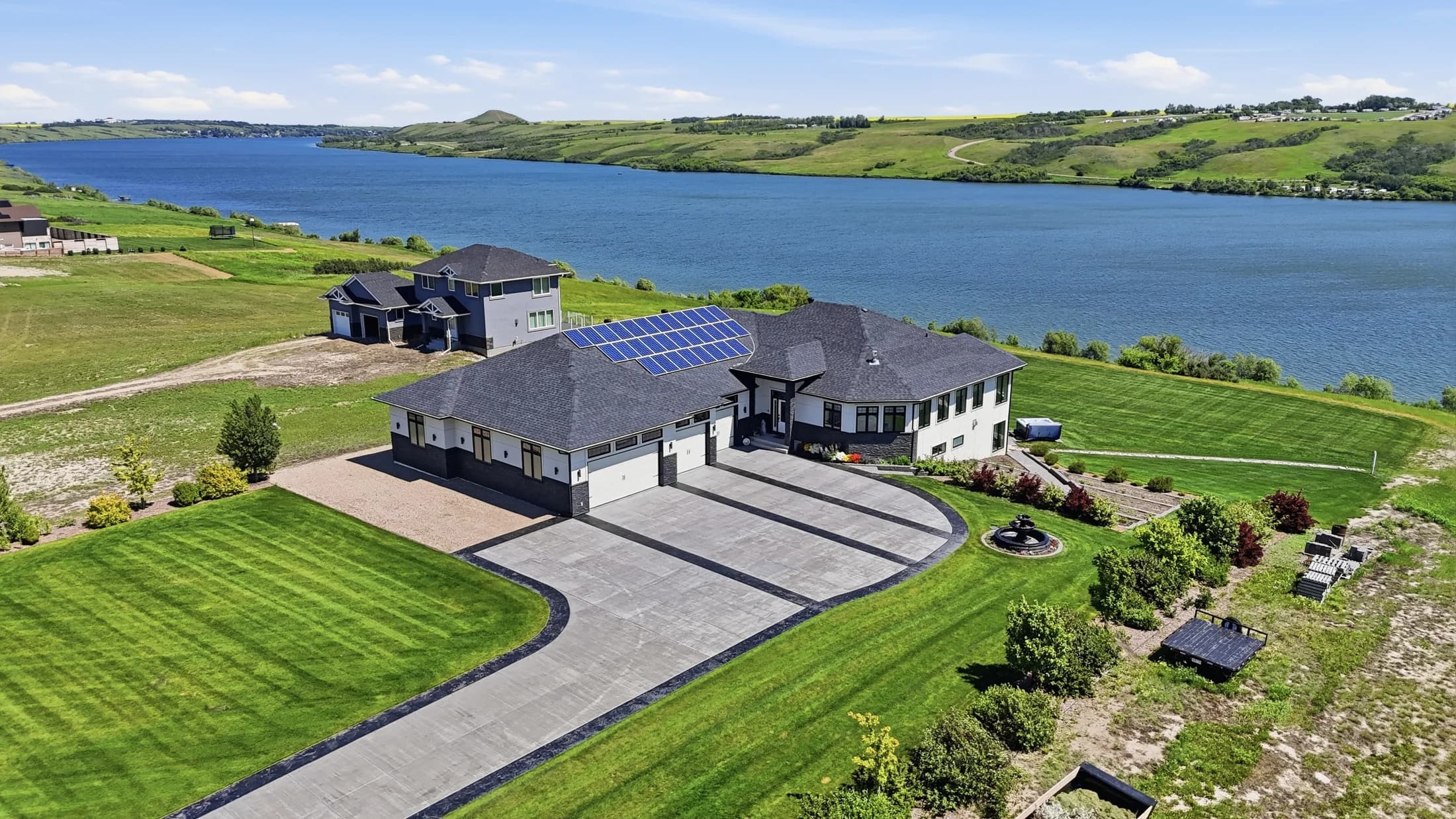 Lakeside home and landscaped driveway with water beyond